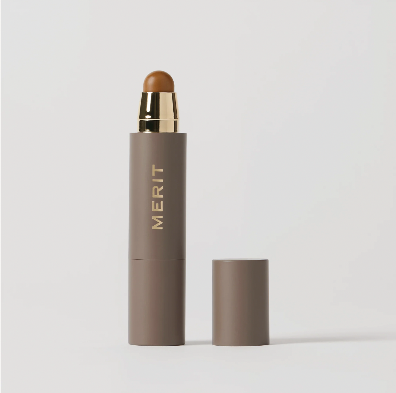 MERIT PERFECTING COMPLEXION STICK against a grey background