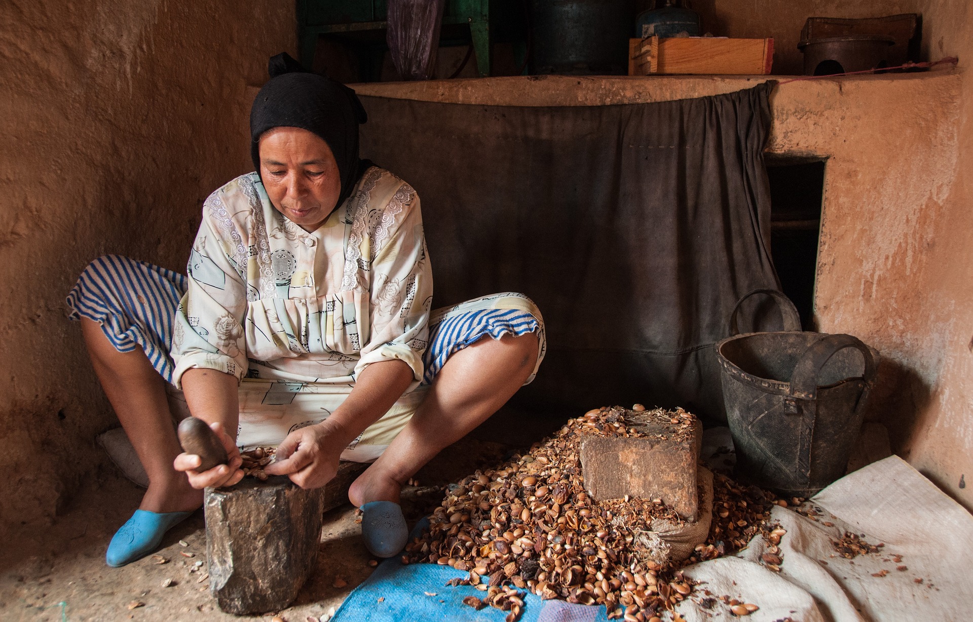 A Moroccan woman grinds argan kernels to make oil