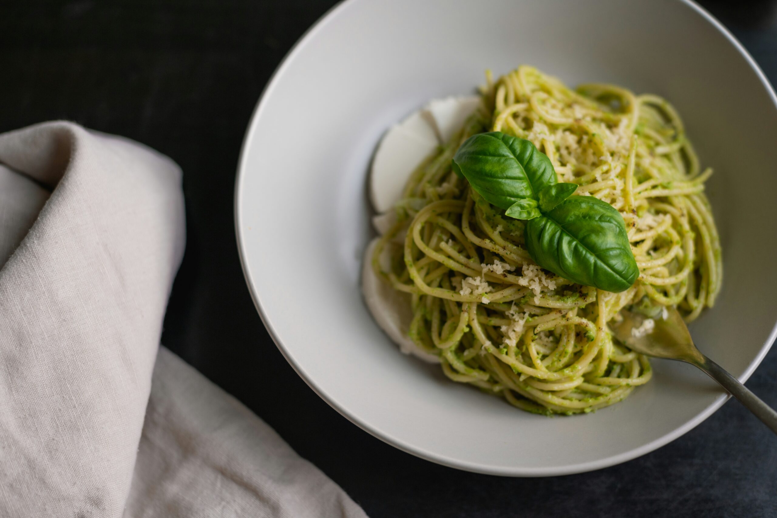 Green pesto spaghetti in a wide bowl