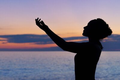 woman releasing trauma with hands in the air