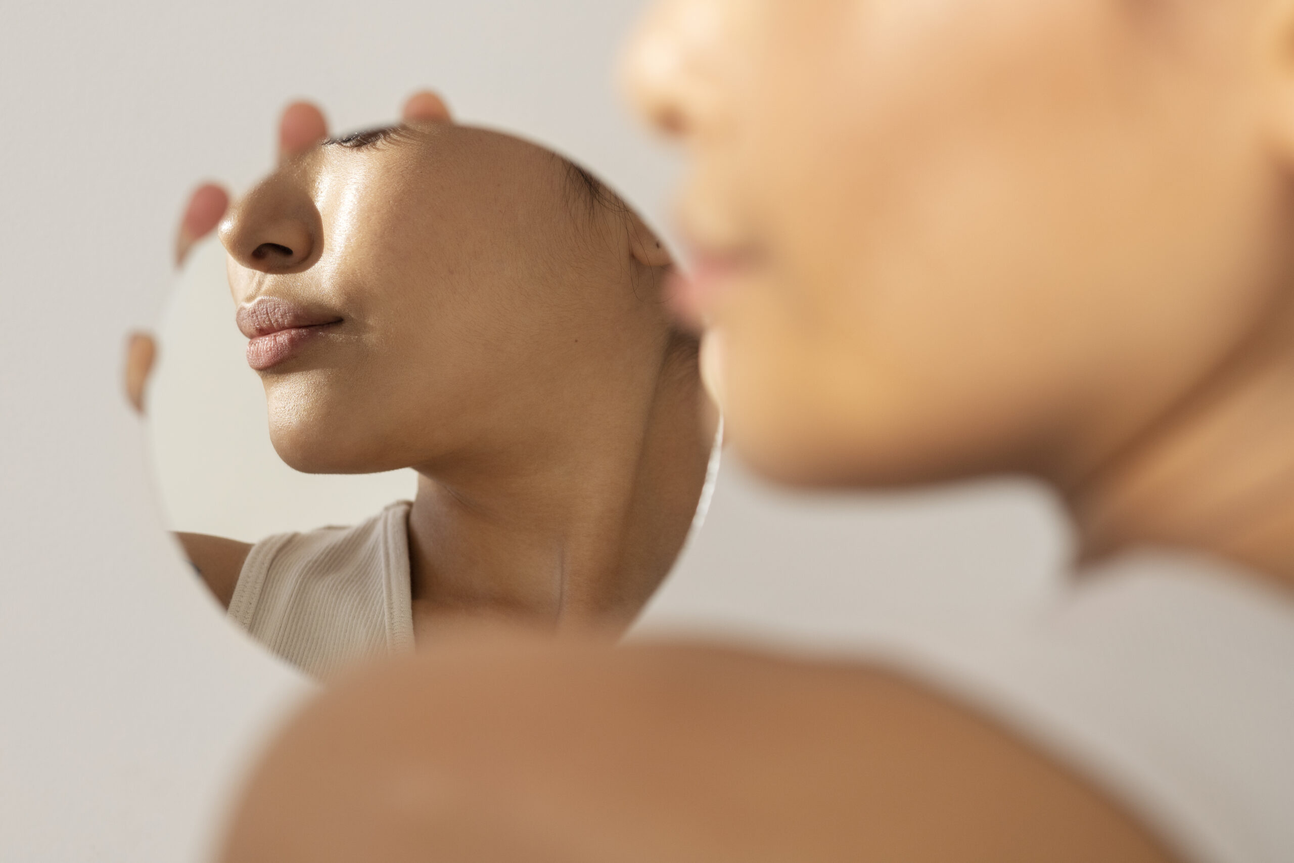 A woman's jawline in the background in a mirror