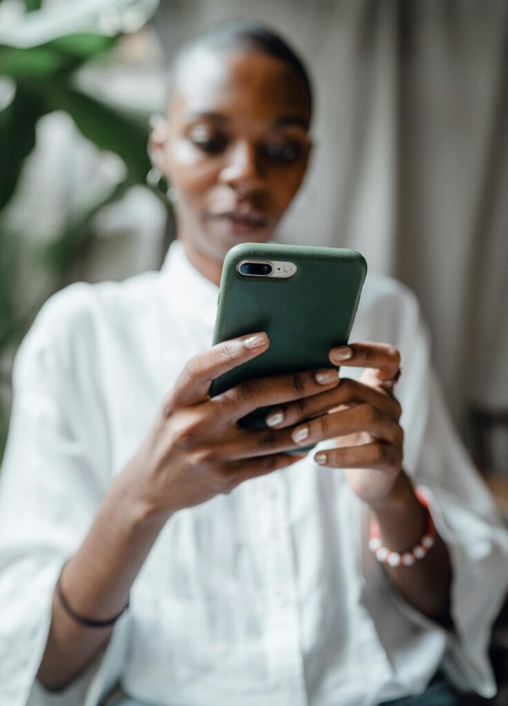 a black women scrolls on her phone