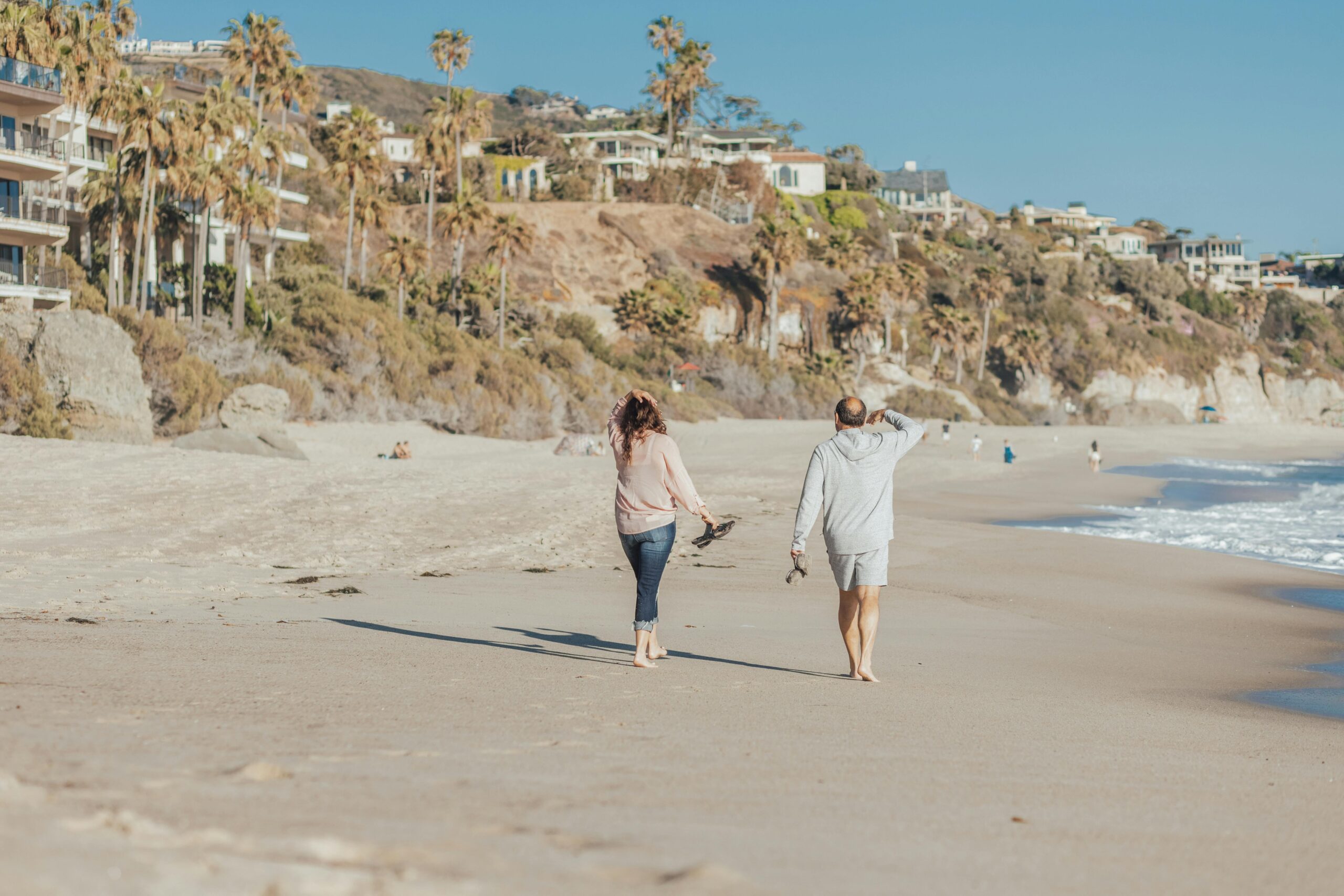 Middle aged couple walk on the beach