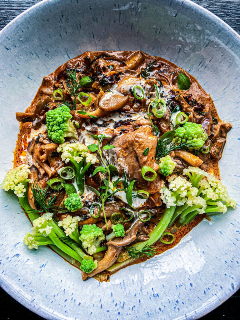 Close up of a black garlic mushroom stroganoff on a grey plate