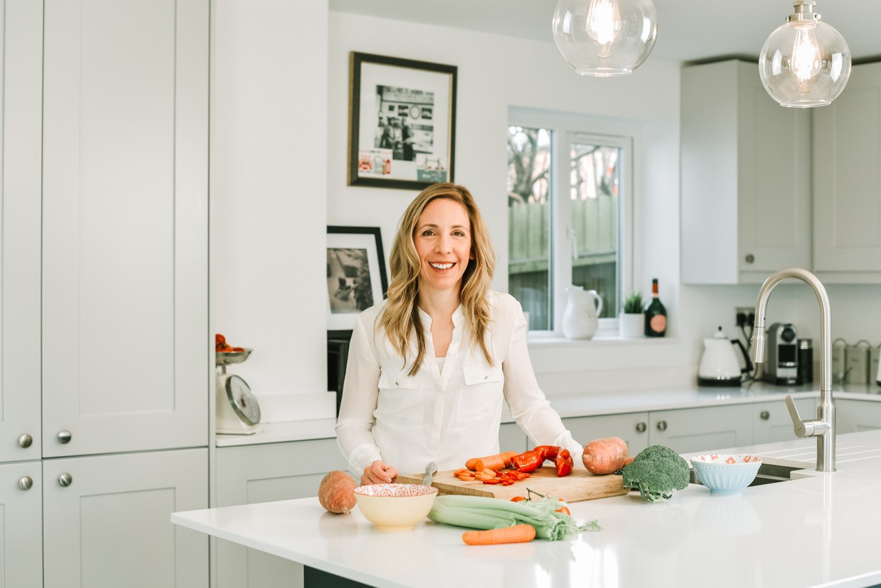 Photo of Elizabeth Sergeant in a kitchen (women’s health coach, functional medicine practitioner and CEO of Well Nourished Club)