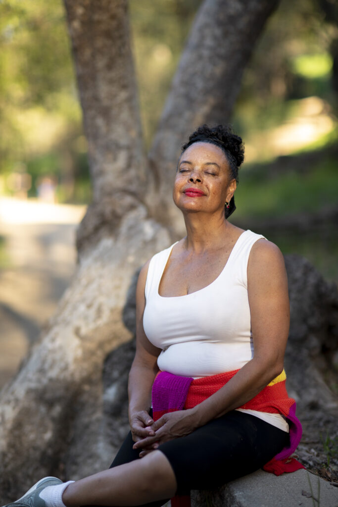 a black women sits and takes a break from walking