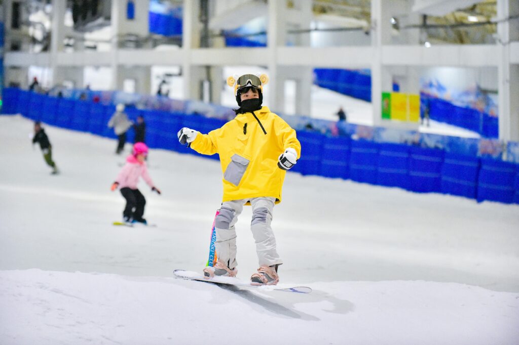 Woman snowboarding down an indoor ski slope