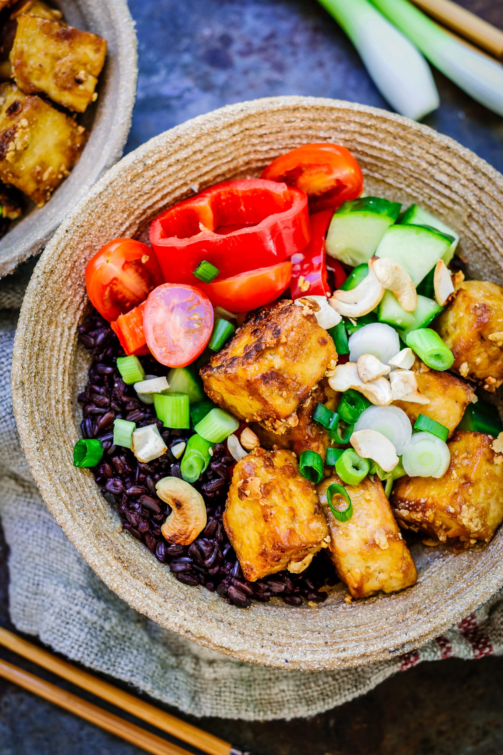Vegan crispy tofu rice bowl with toasted cashews.