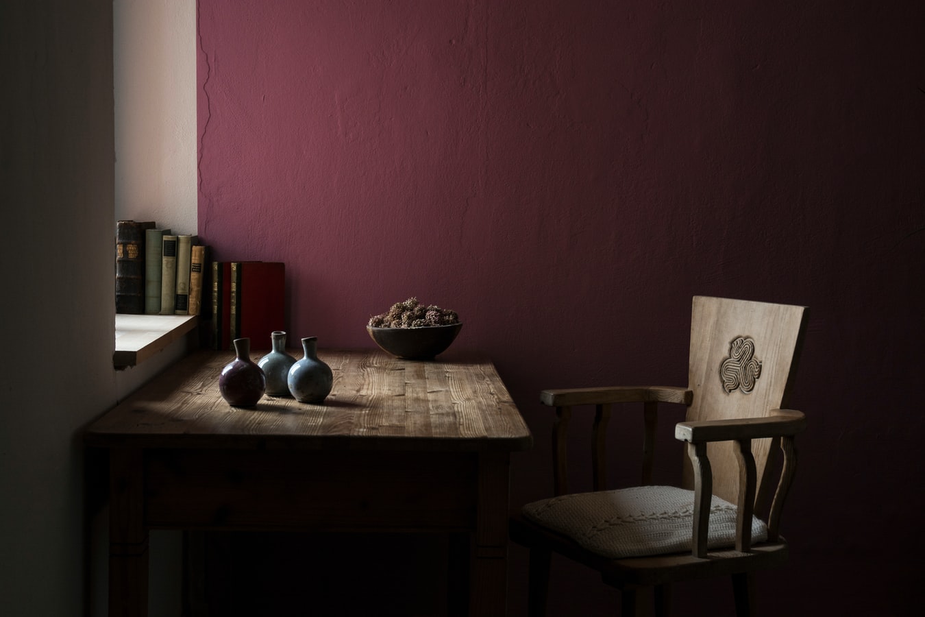 Daylight lights a beautiful study room with a mauve wall.