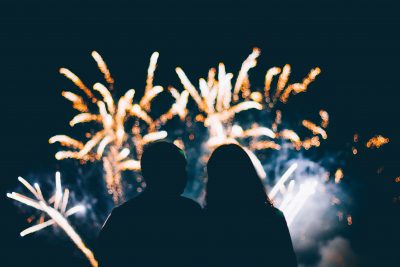 Silhouette of a couple watching a firework display at night