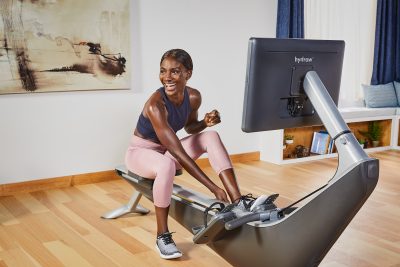 A woman prepare to train on a Hydrow silent rowing machine in her studio