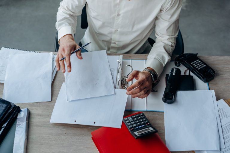 A man runs through his finances on a calculator.