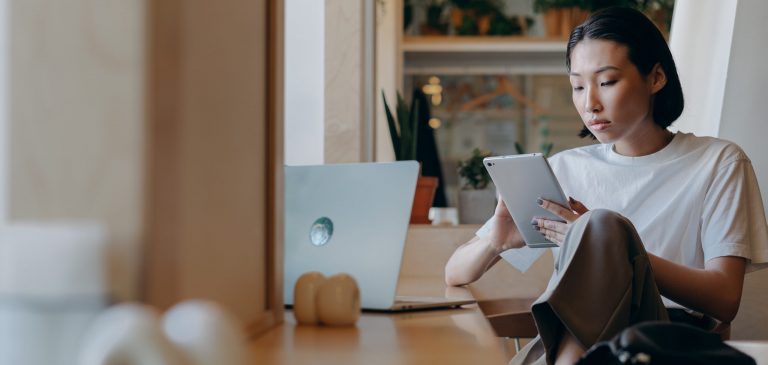 A woman invests in the future using her laptop and iPad