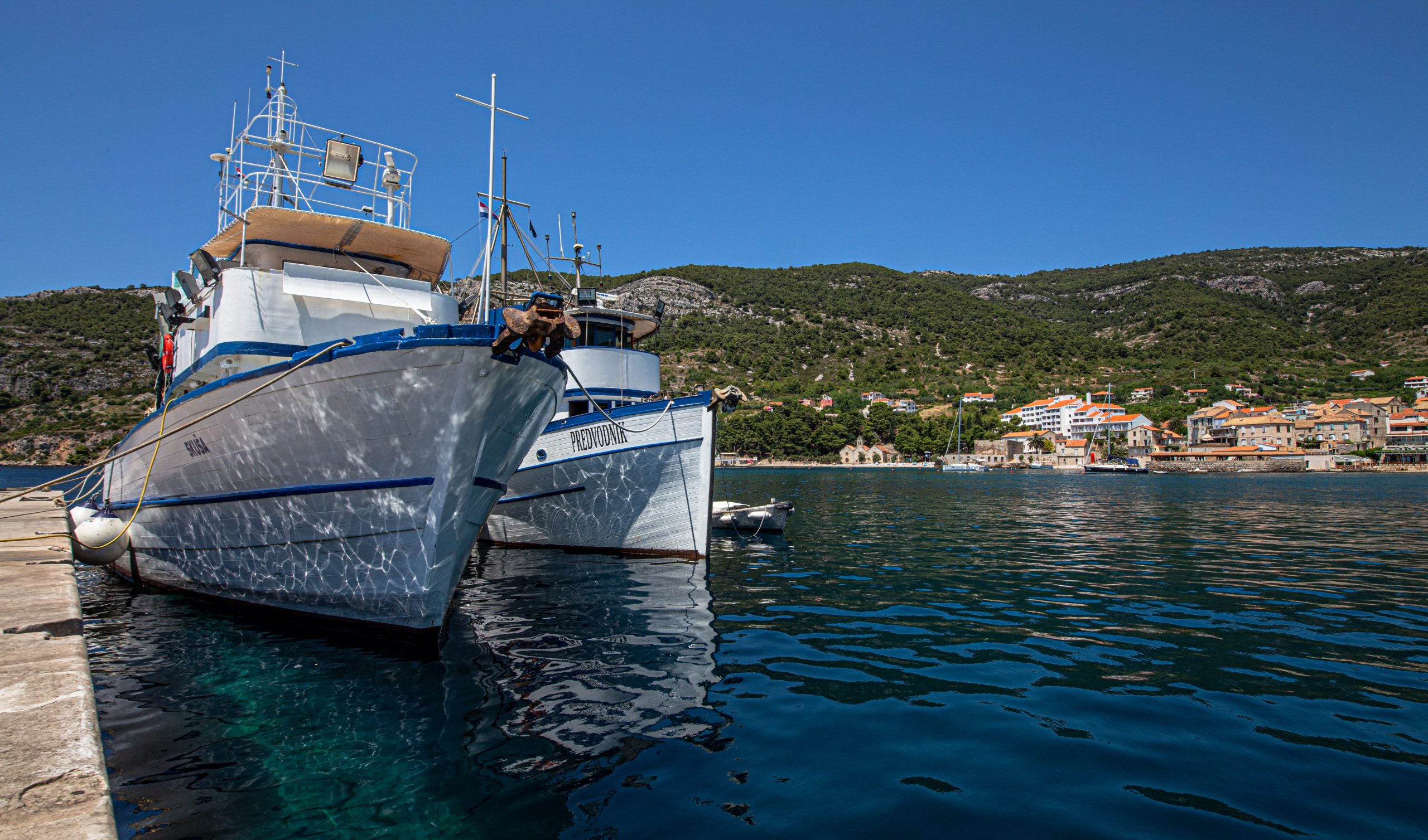 Harbour view of two boats docked at Vis, Croatia on a hot day.