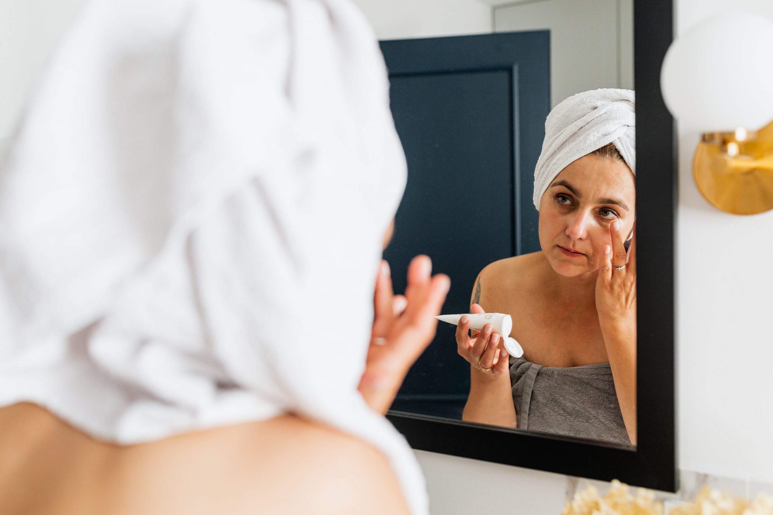 A woman applies makeup to her face