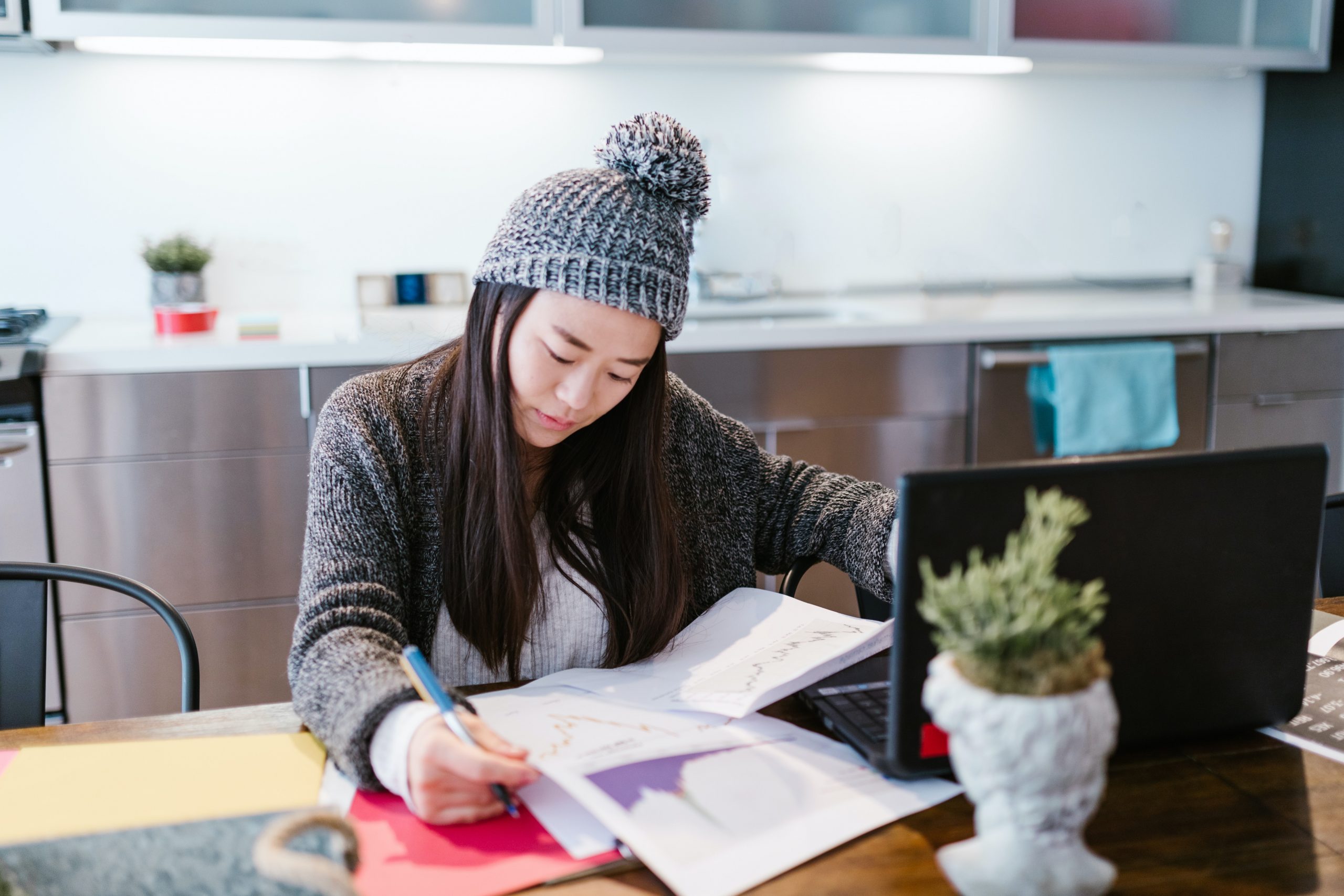 A woman reviews the pros and cons of impact investments on her laptop.