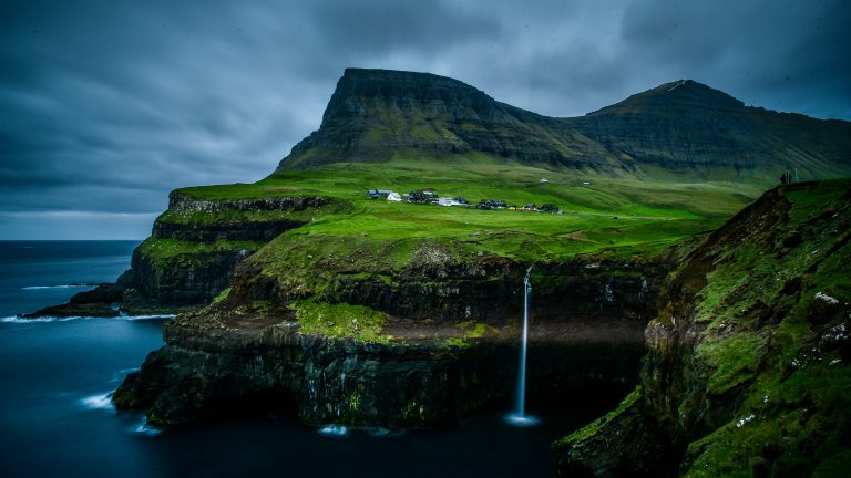 The green valley of Gasadalur village with its waterfall in the Faroe Islands, Denmark.