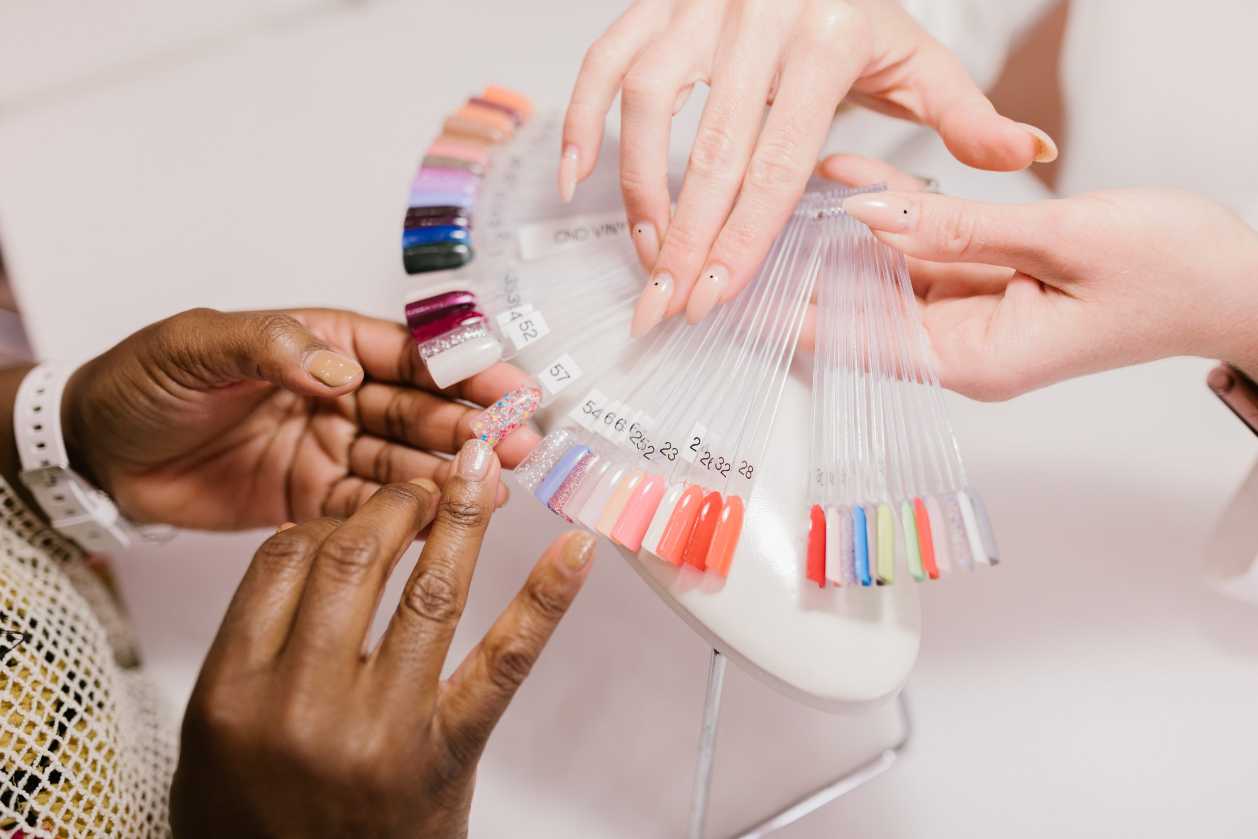 An array of coloured nails is offered to a woman. 