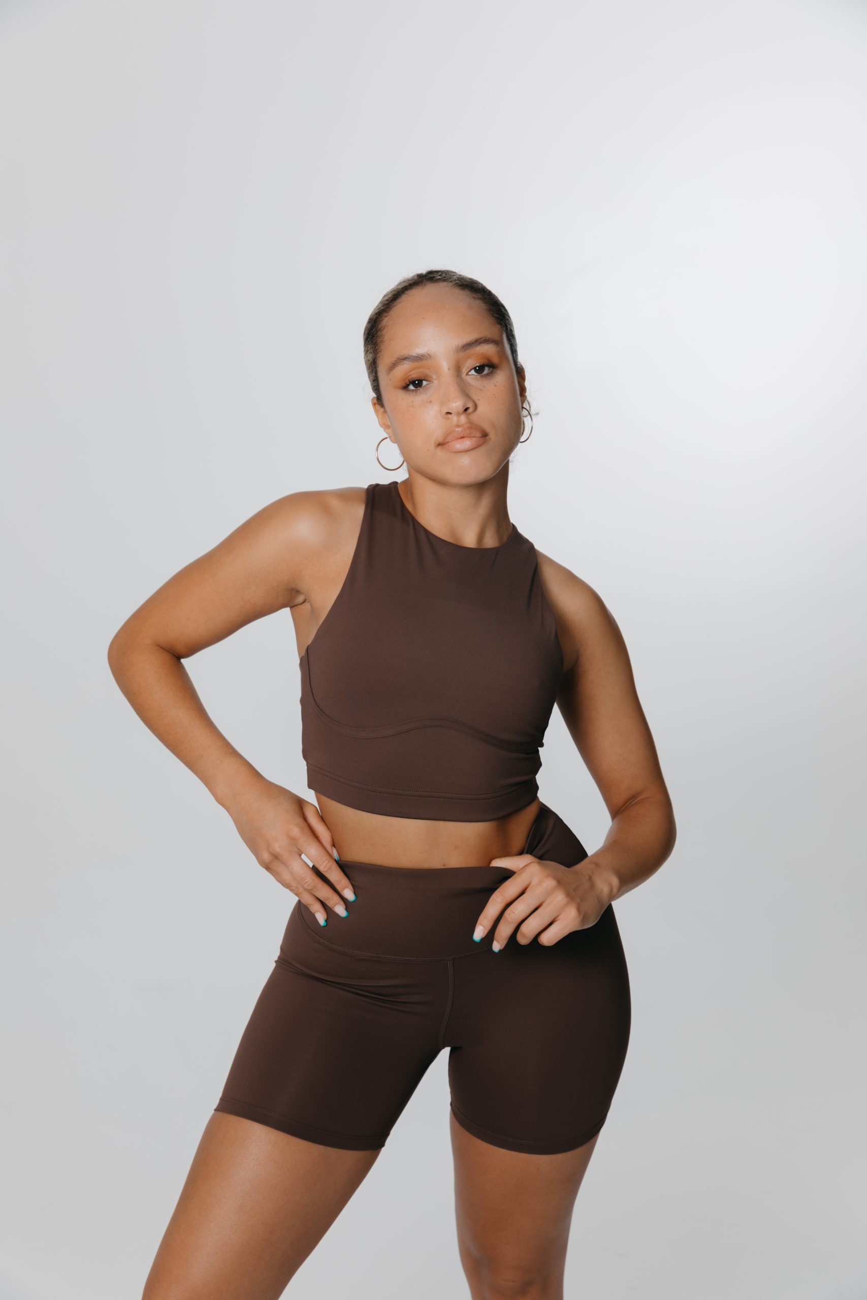 A woman modelling a brown outfit from TALA's activewear collection