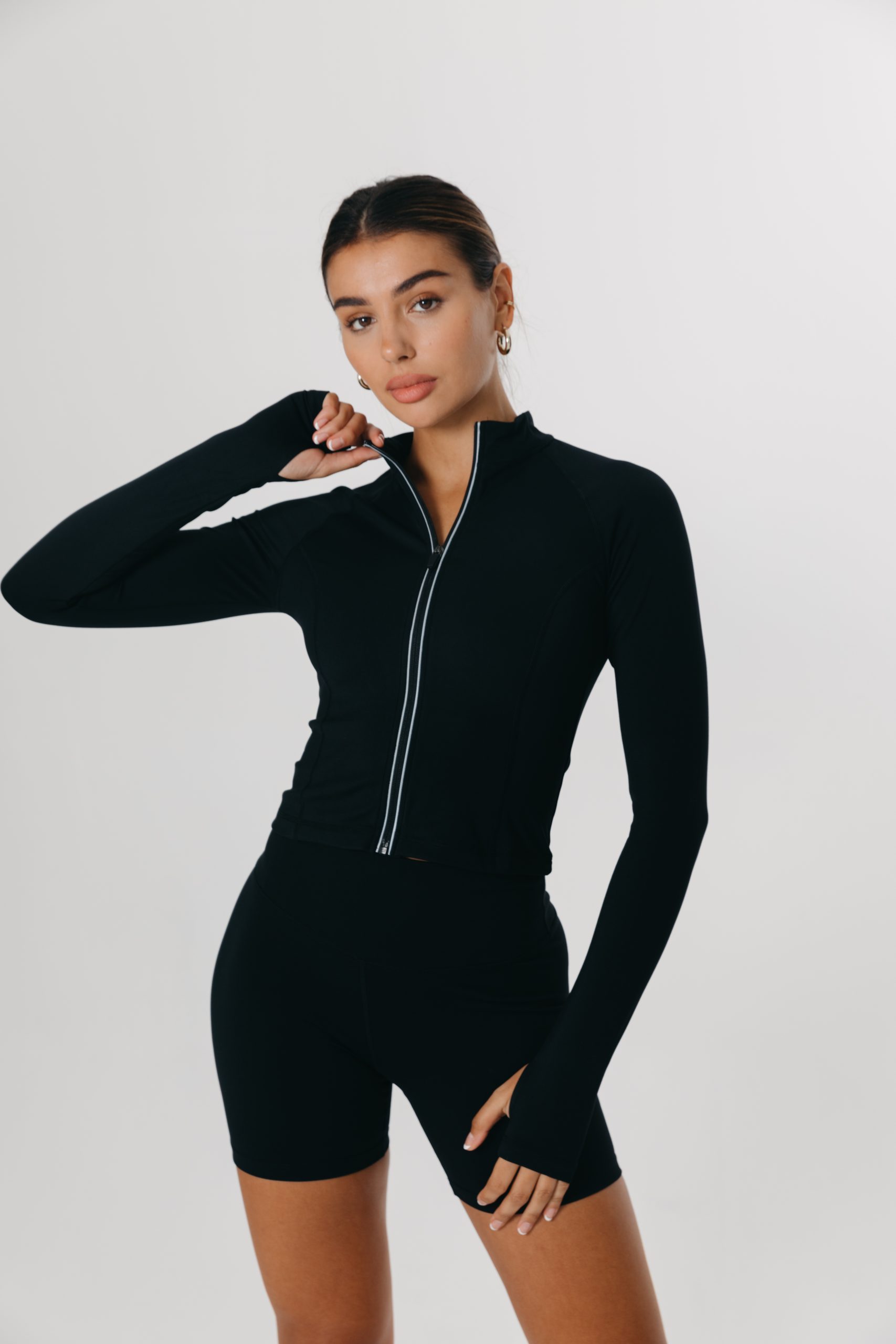 A young woman modelling a black outfit from TALA's activewear collection