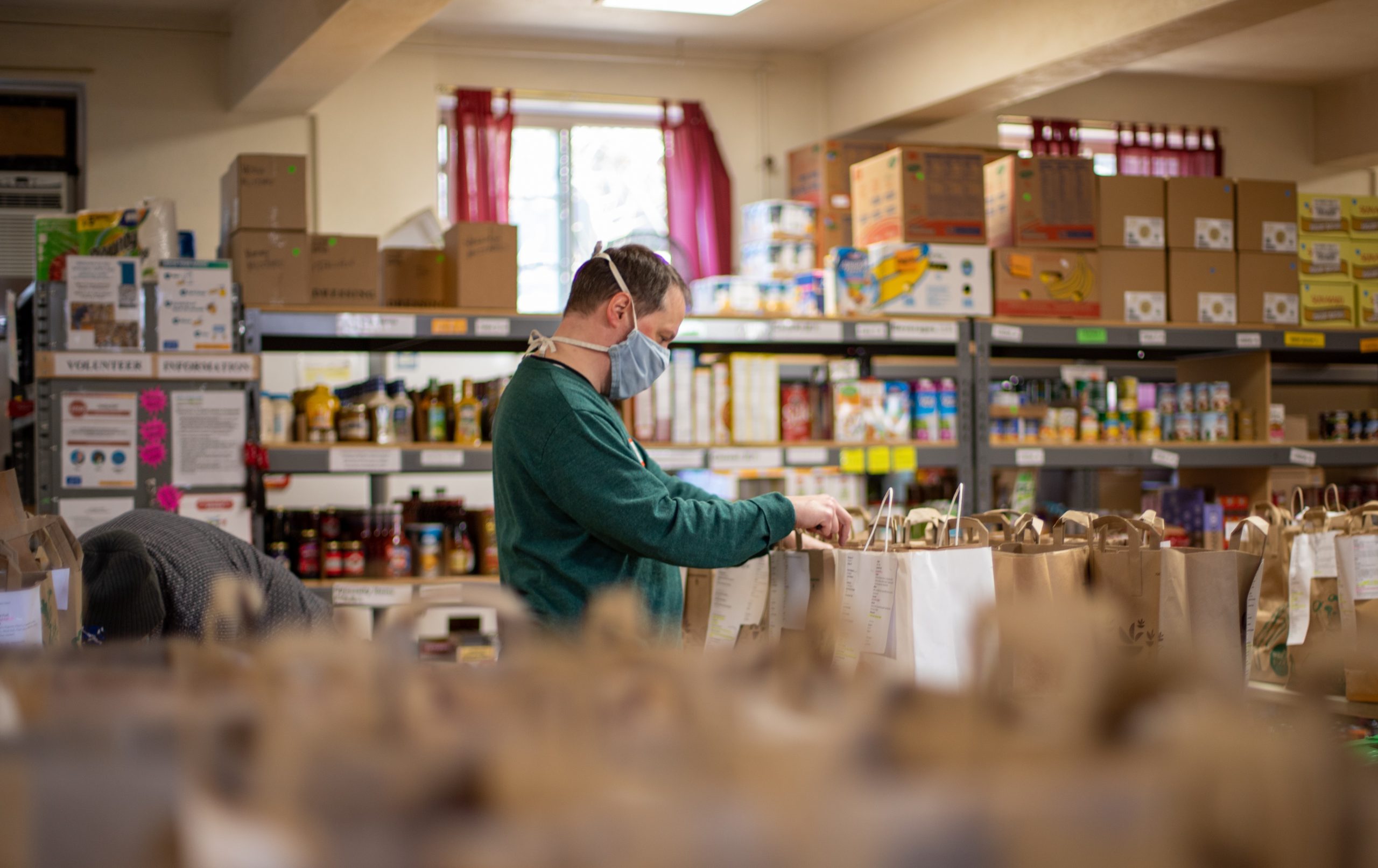 A volunteer in a local food bank prepares the orders due to be shipped out
