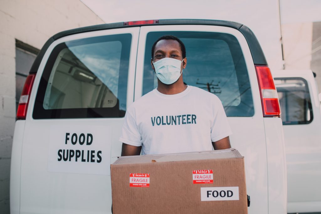 A volunteer for a charity helps with the delivery of food