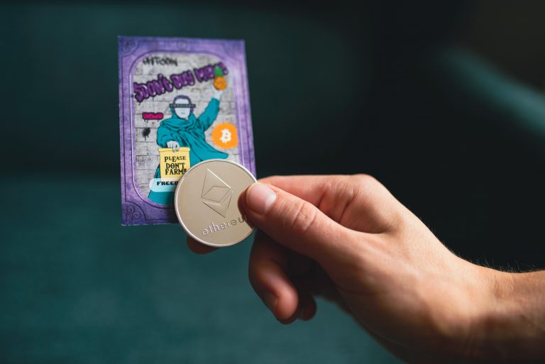 A hand holds an Ether, a cryptocurrency.