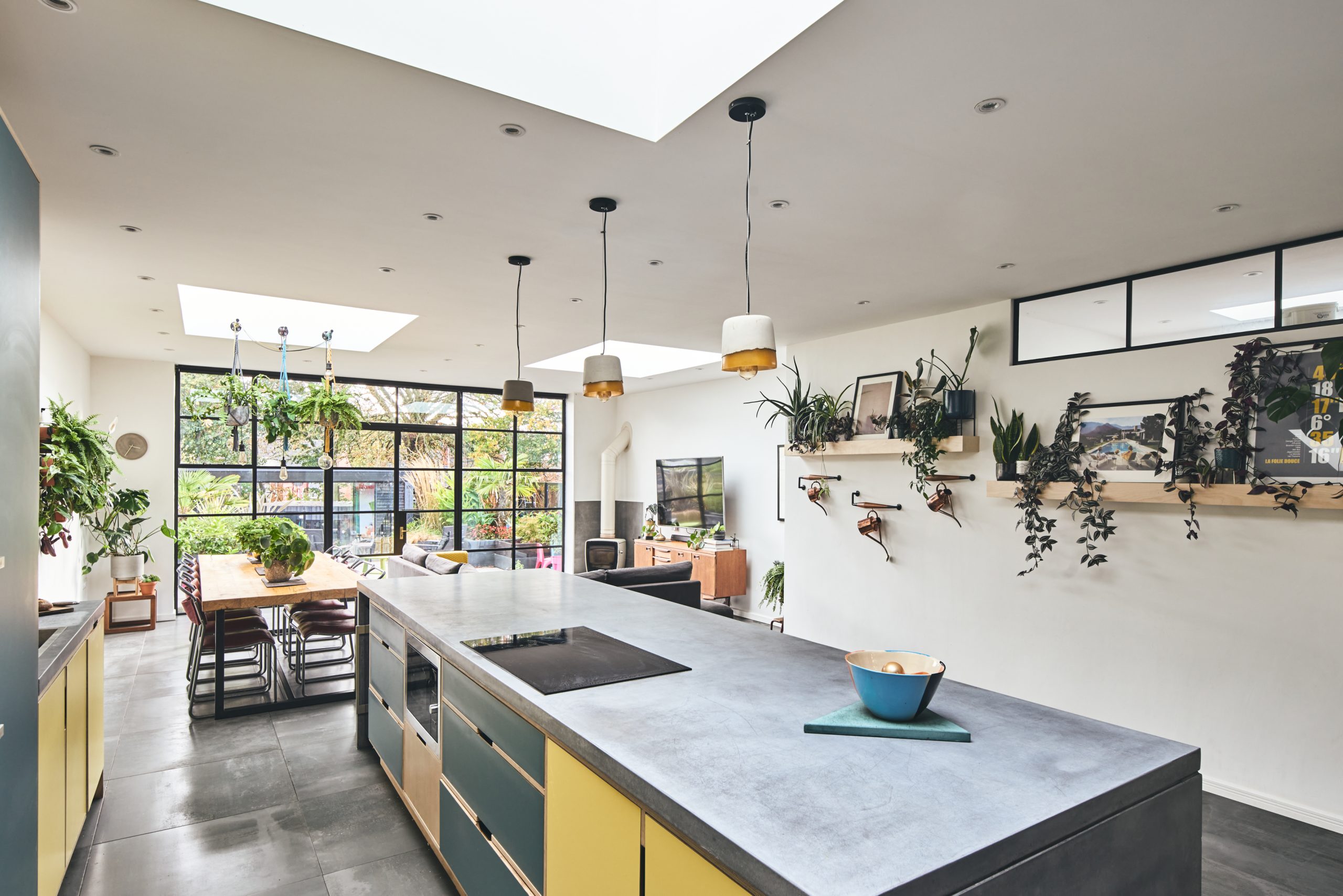 A modern open-plan kitchen/dining area with skylights.