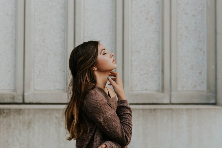 A woman in profile focuses on breathing.