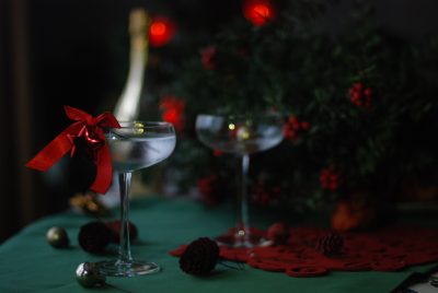 Two Christmas cocktails - one served with a red ribbon.