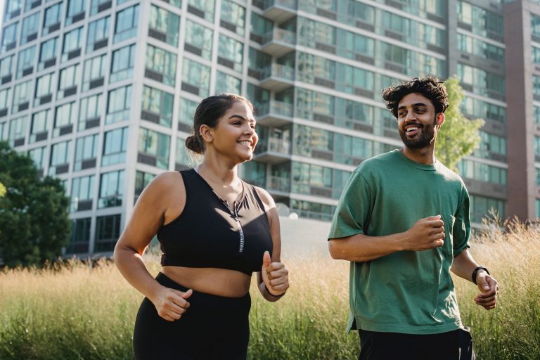 An Asian young woman and man keep fit by jogging.
