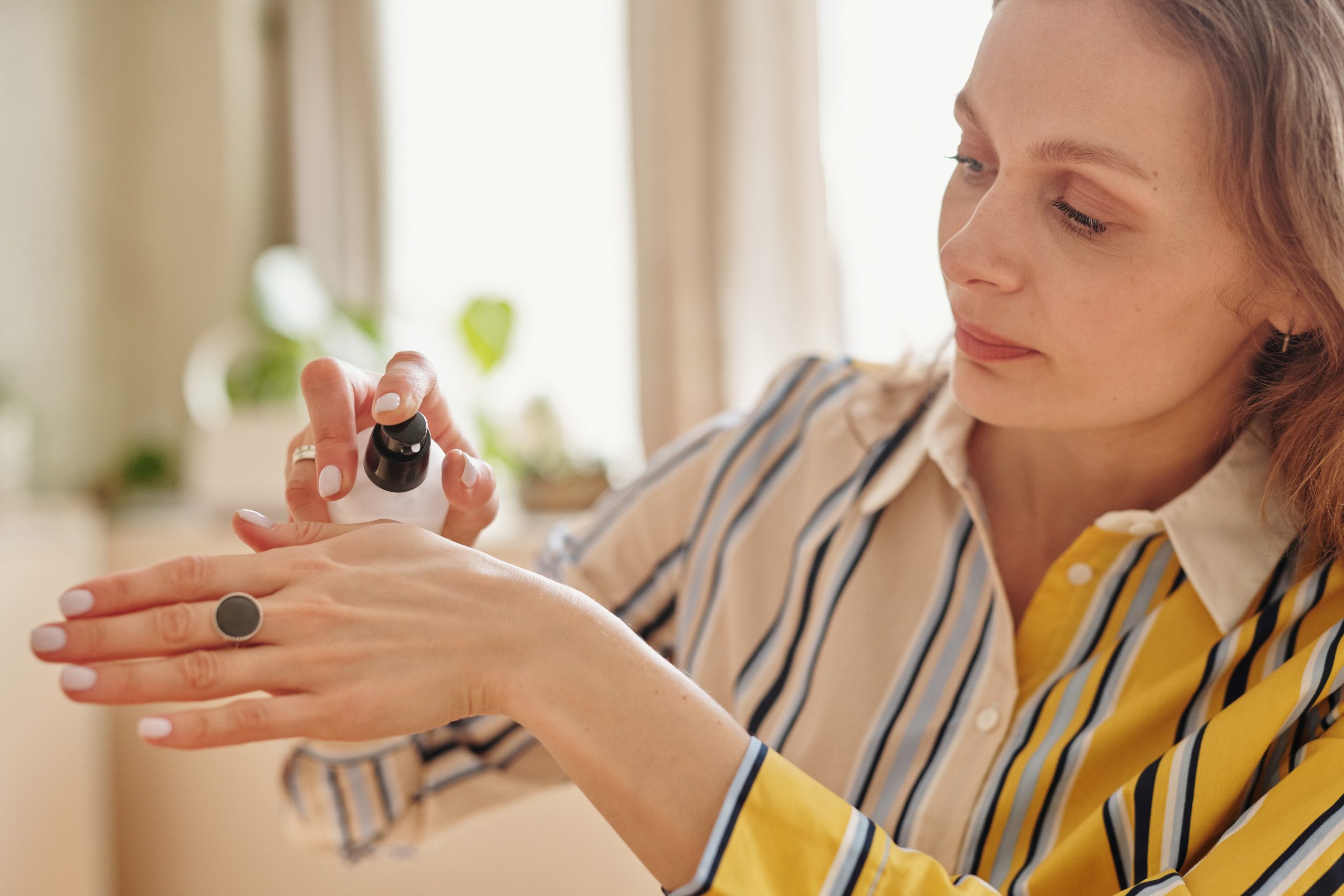 A woman applies moisturiser to her hands during menopause.
