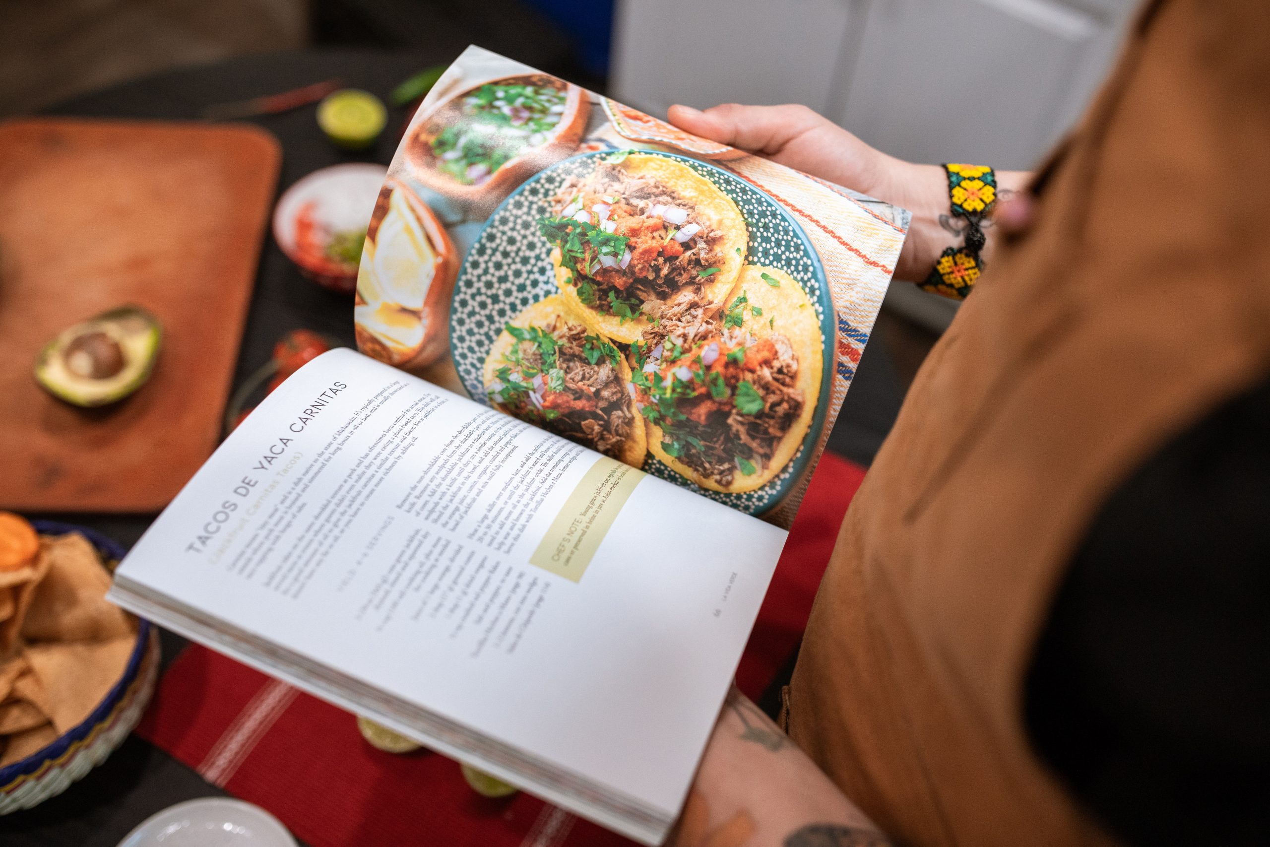 A woman reads Leon Happy One-pot Vegetarian cookbook, by Rebecca Seal and Chantal Symons