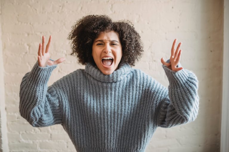 A black woman throws her hands up in the air, venting her anger.