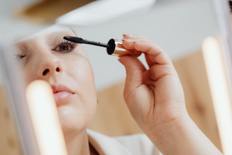 A pretty woman applies Maybelline New York Lash Sensational to her eyelashes.