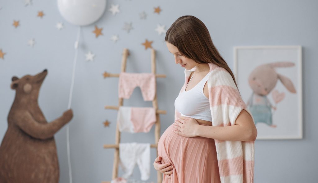 A young pregnant woman standing in her plastic free nursery.