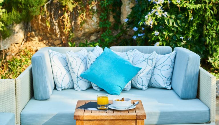 A light blue sofa with a bright blue cushion on it.