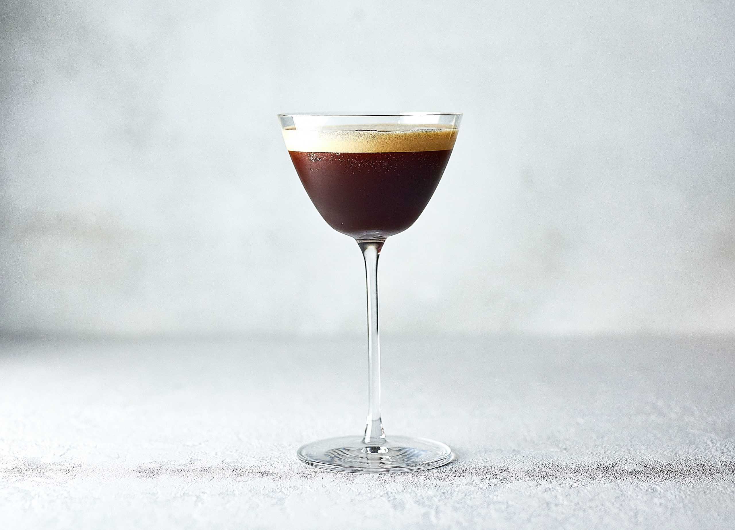 An Espresso martini cocktail against a white background.