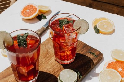 Two Grapefruit spritz cocktails on a wooden platter.