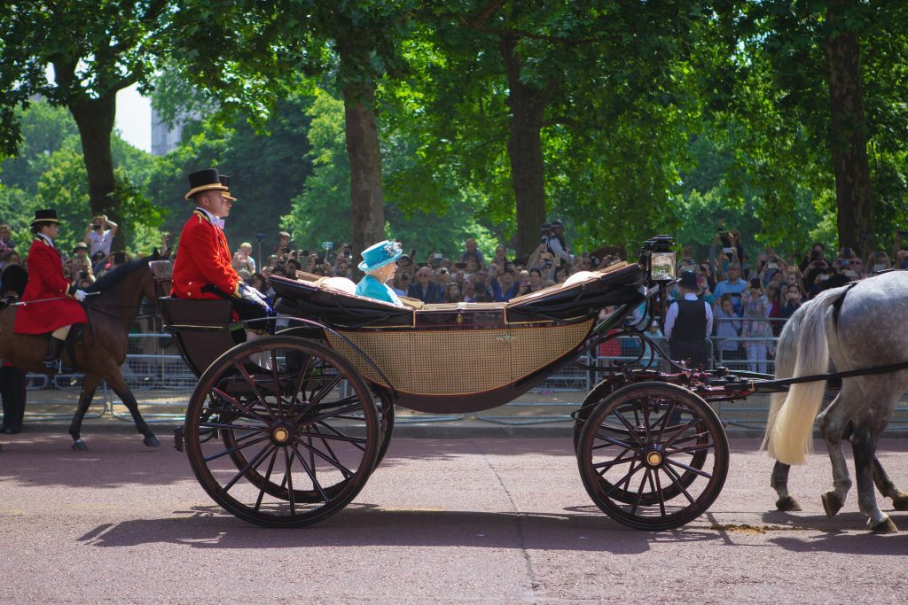 The Queen riding her horse-drawn carriage.