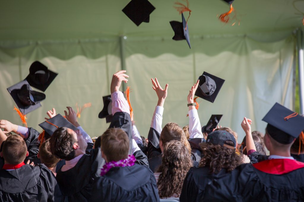 A group of graduates throwing their caps up in the air.