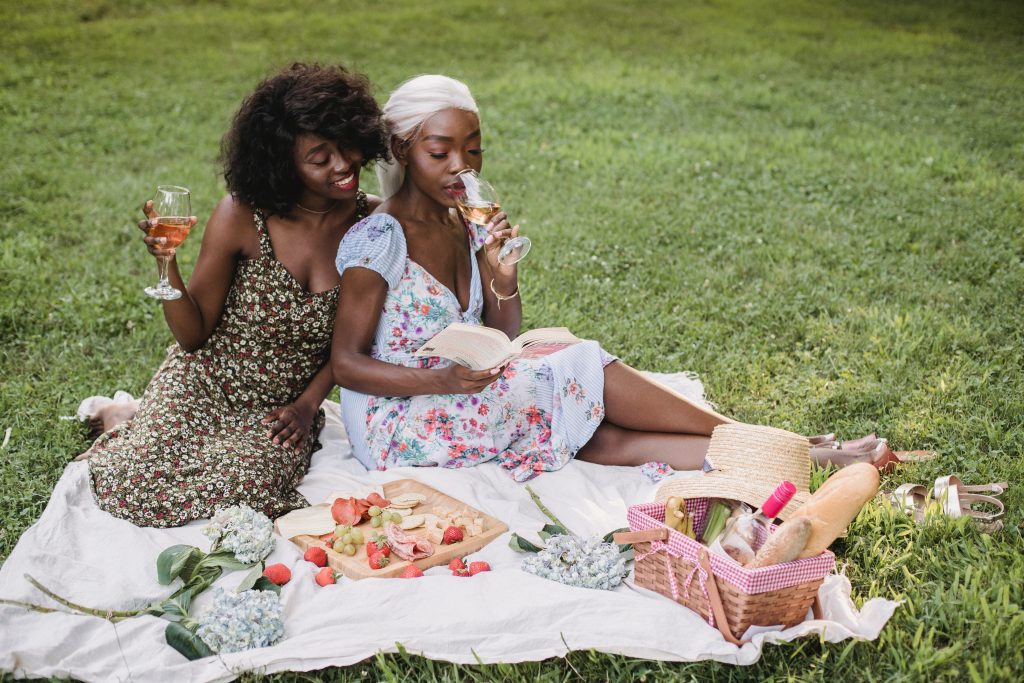 A female couple enjoying a summer picnic in the park.