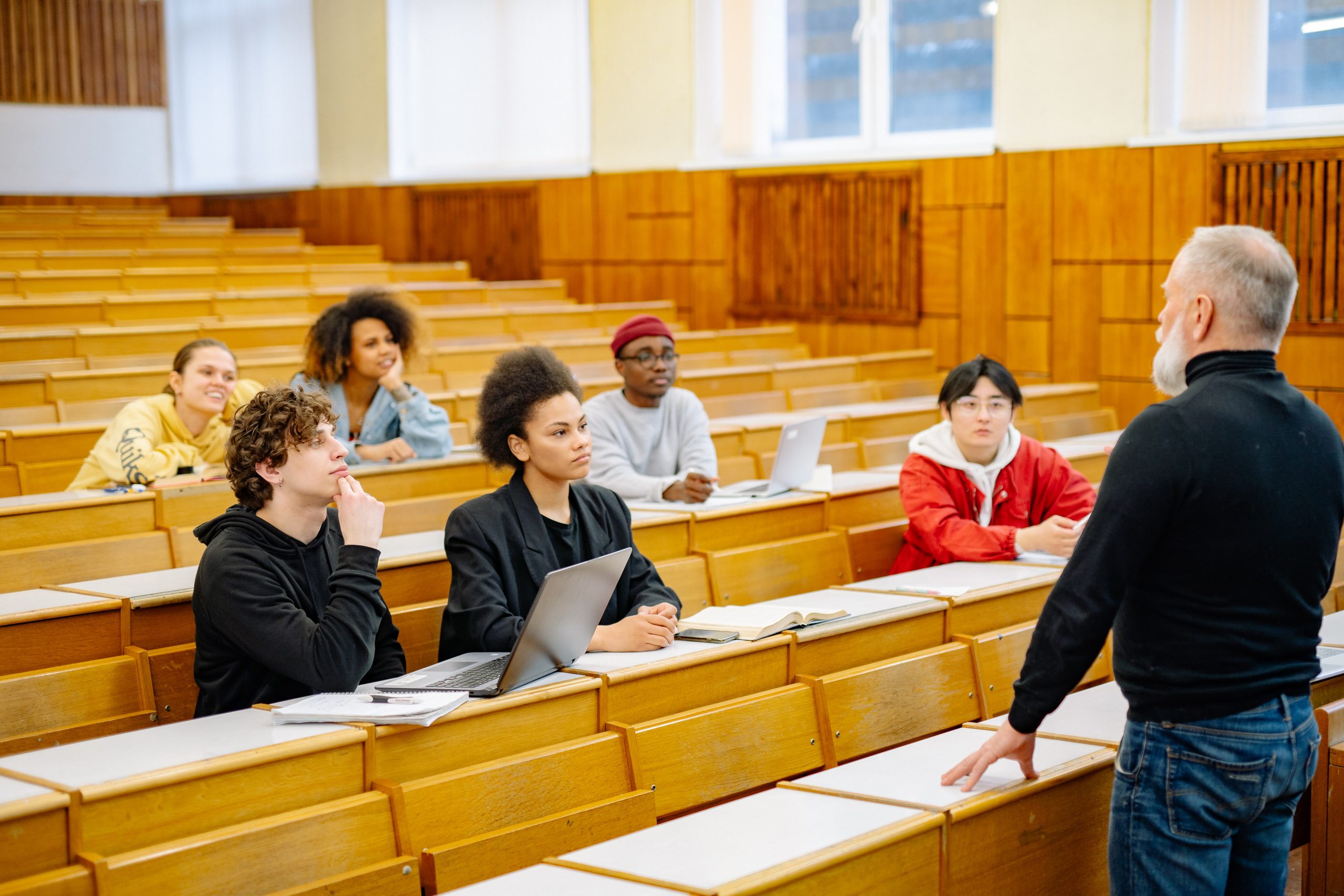 A university lecturer teaching a class to a small group of international students.