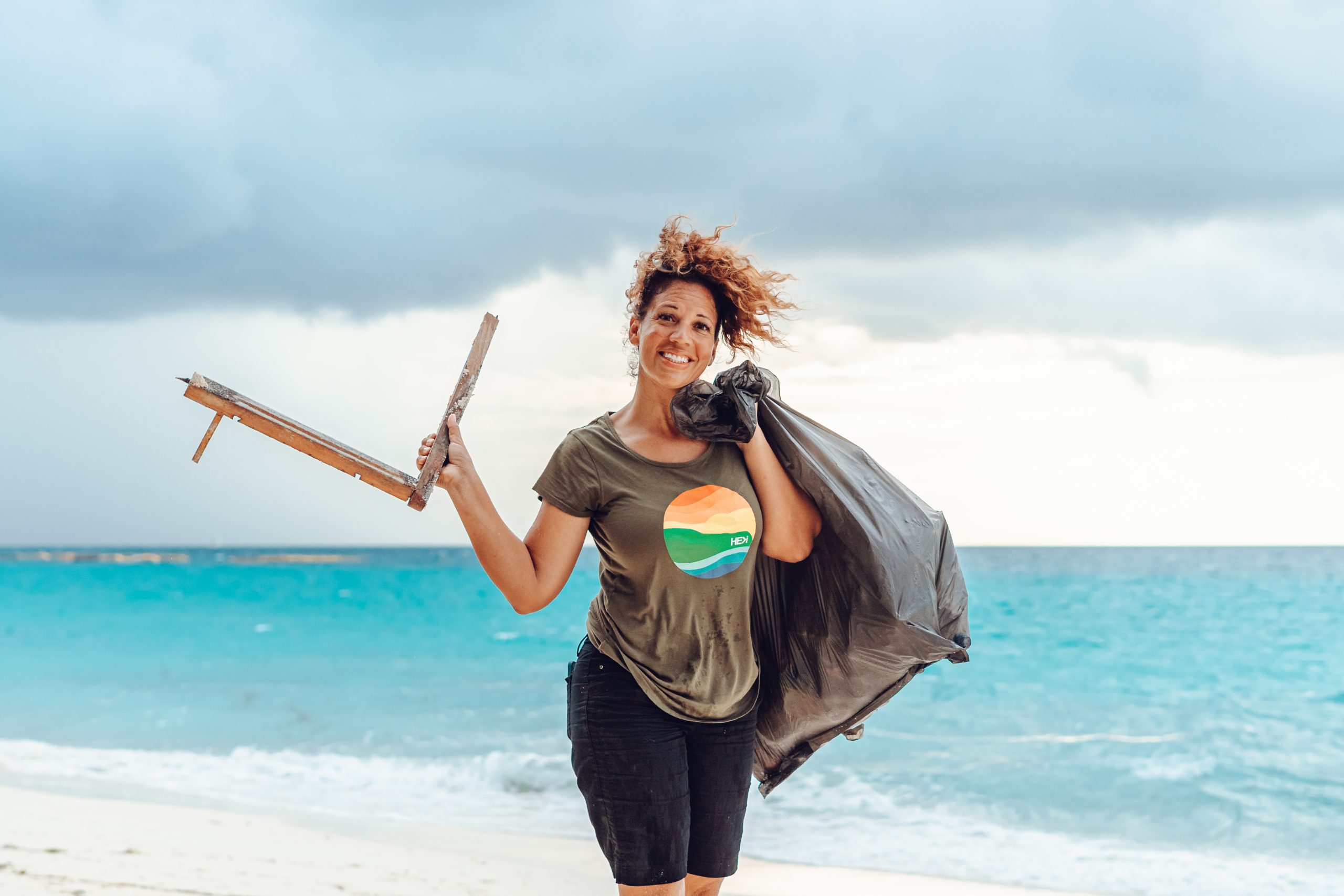 A young woman posing with the debris she's collected from the beach in the Maldives.
