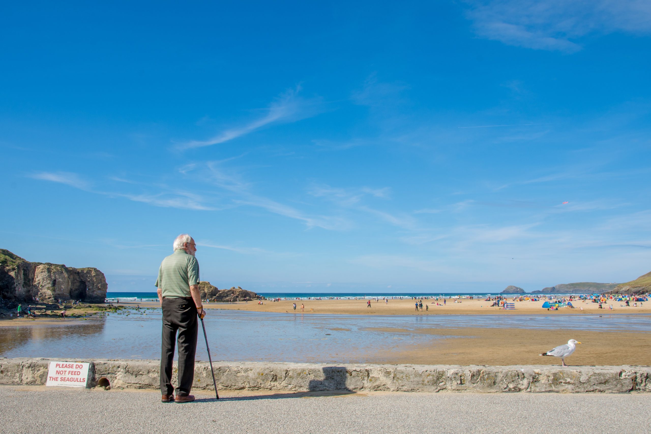 An old man looking out across the beach of Perranporth, Cornwall.