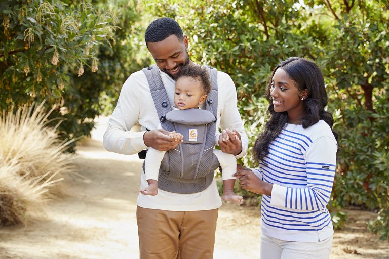 A couple carrying their baby in a Ergobaby Omni Breeze carrier.