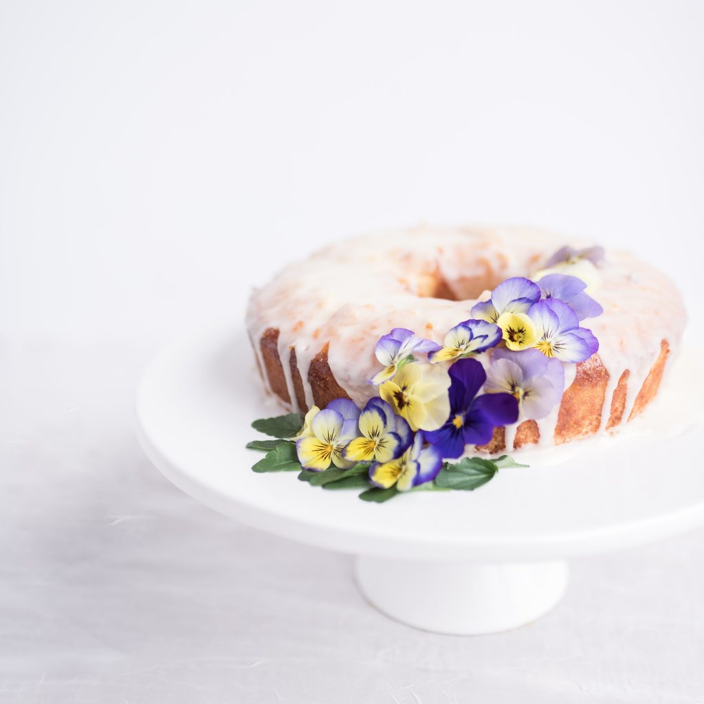 Sugared elderflower bundt cake decorated with crystallised flowers.