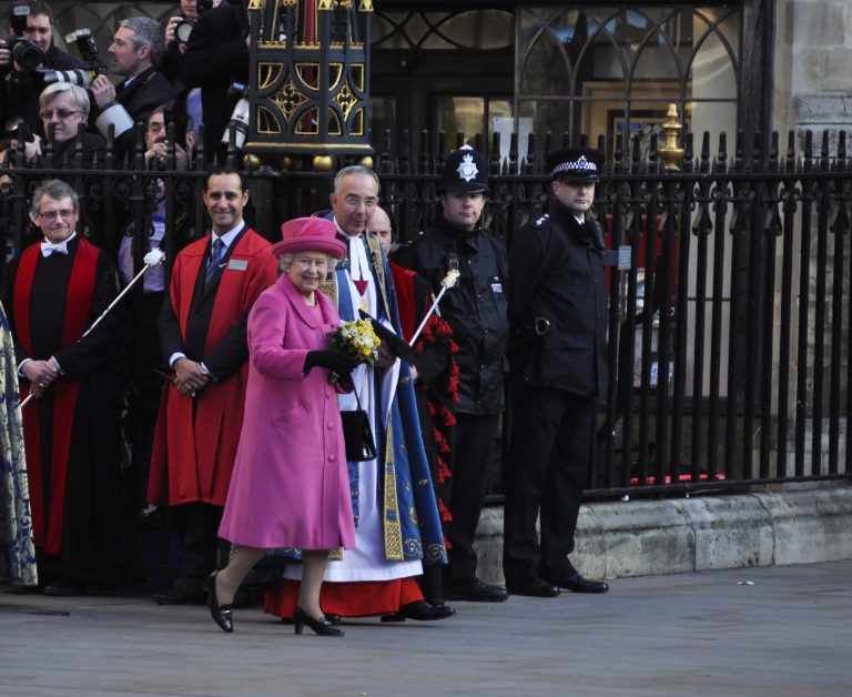 In her pink coat and hat, Queen Elizabeth II smiles for the cameras outside Westminster Abbey in March, 2012.
