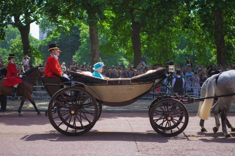 Queen Elizabeth II being driven in her horse-drawn carriage.