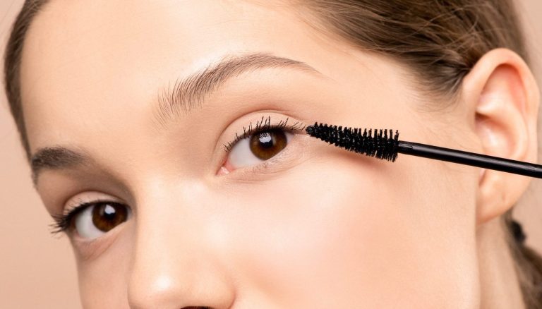 close up of woman applying a waterproof mascara to one eye